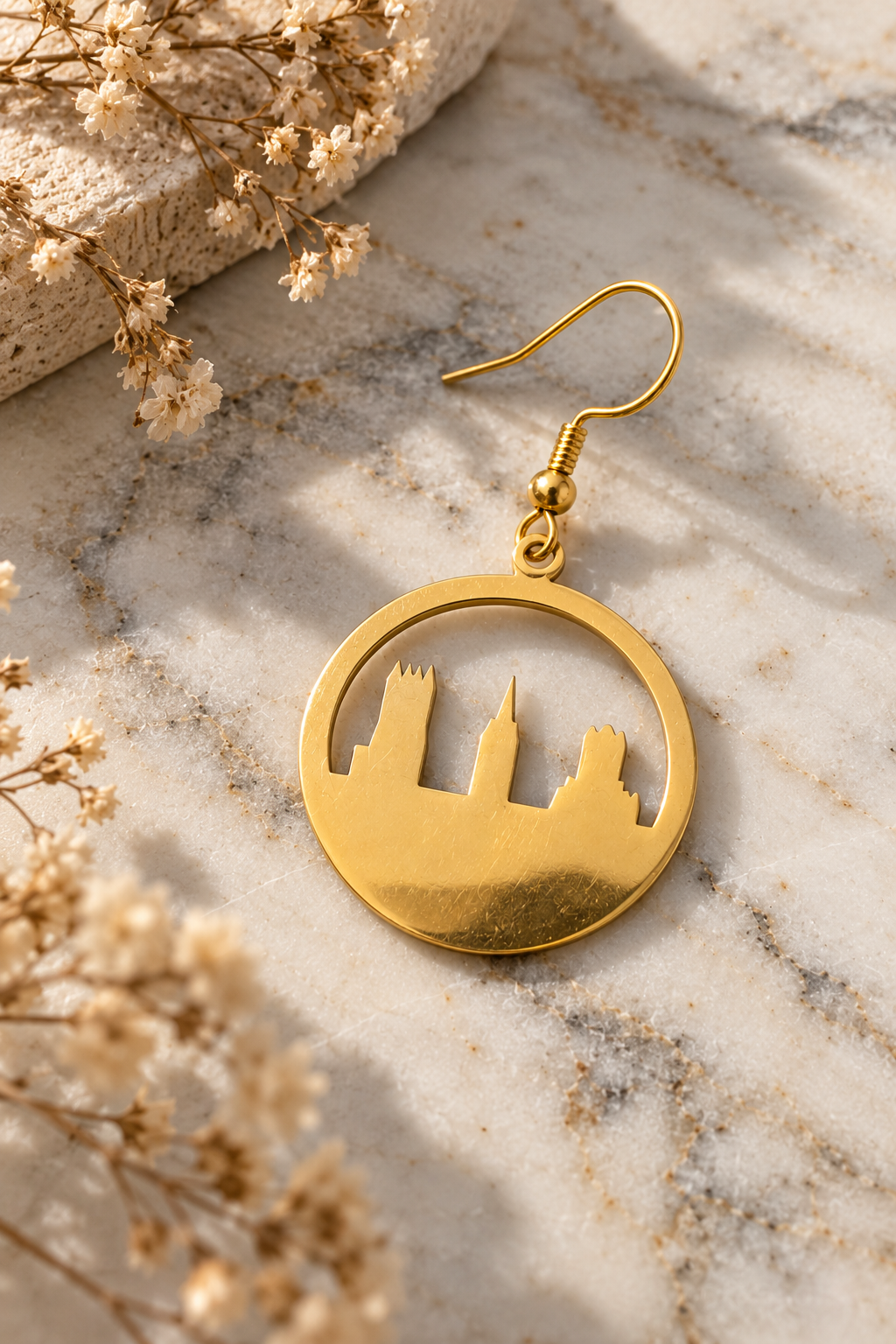 Gold Circle Skyline Earrings by Van Gent Studio on light marble with dried flowers